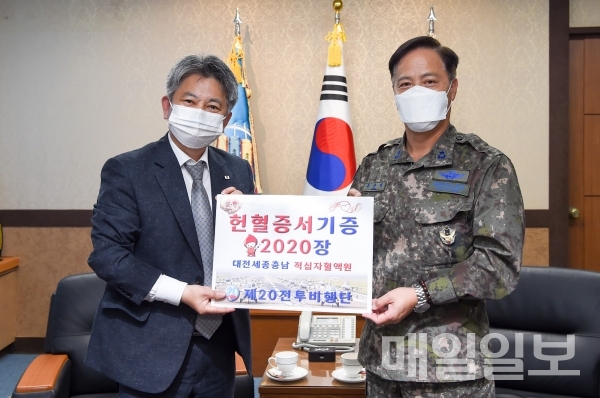 제20전투비행단장 홍순택 준장(우)과 대한적십자사 손일수 대전세종충남혈액원장(좌)이 헌혈증 기부 기념 사진을 촬영하고 있다./제공=중사 이재민