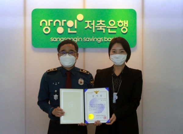 정은경 상상인저축은행 대리(오른쪽)가 18일 부천원미경찰서로부터 보이스피싱 예방 공로 감사장을 받고 심재현 상동지구대 경감과 기념촬영을 하고 있다. 사진= 상상인저축은행 제공.