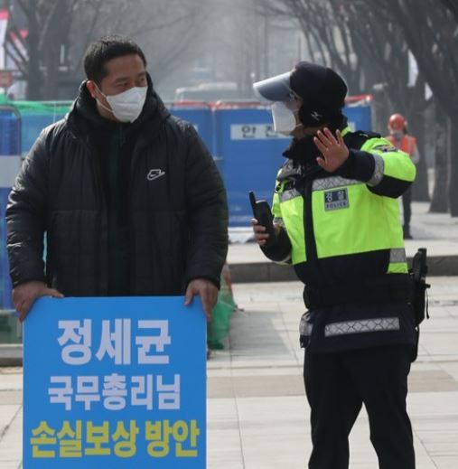 중소상인과 실내체육시설 단체 회원이 22일 정부서울청사 앞에서 코로나19 거리두기 관련 재난지원금이 아닌 손실보상을 촉구하는 1인 시위를 벌이고 있다. 사진=연합뉴스
