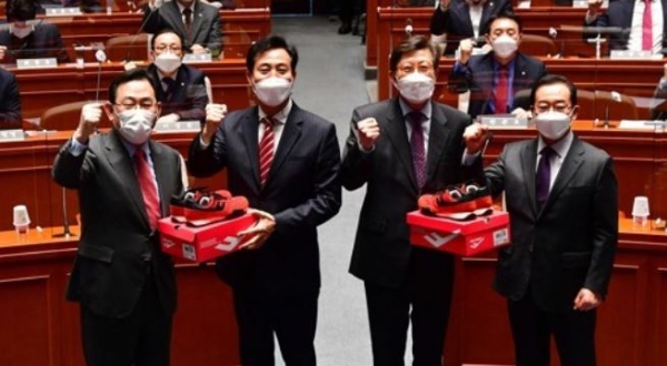 국민의힘 오세훈 서울시장 후보와 박형준 부산시장 후보가 5일 오전 국회에서 열린 의원총회에 참석해 주호영 원내대표와 이종배 정책위의장으로부터 빨간 운동화를 받고 있다. 사진=연합뉴스