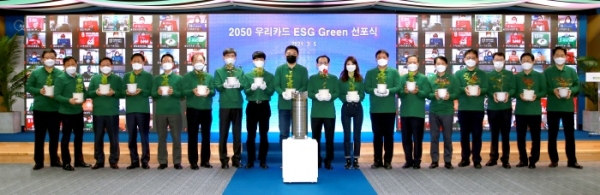 지난 5일 우리카드 광화문 본사에서 열린 ‘2050 우리카드 ESG Green 선포식’에서 김정기 사장(왼쪽 열번째) 및 임직원들이 플라스틱 폐기물로 만든 화분을 들고 기념사진을 촬영하고 있다. 사진=우리카드 제공.