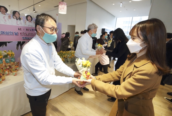 (왼쪽부터) 구현모 KT 대표와 최장복 KT 노조위원장이 광화문에 위치한 KT 동관 사옥에서 여성 임직원에게 꽃을 나눠주고 있다. 사진=KT 제공