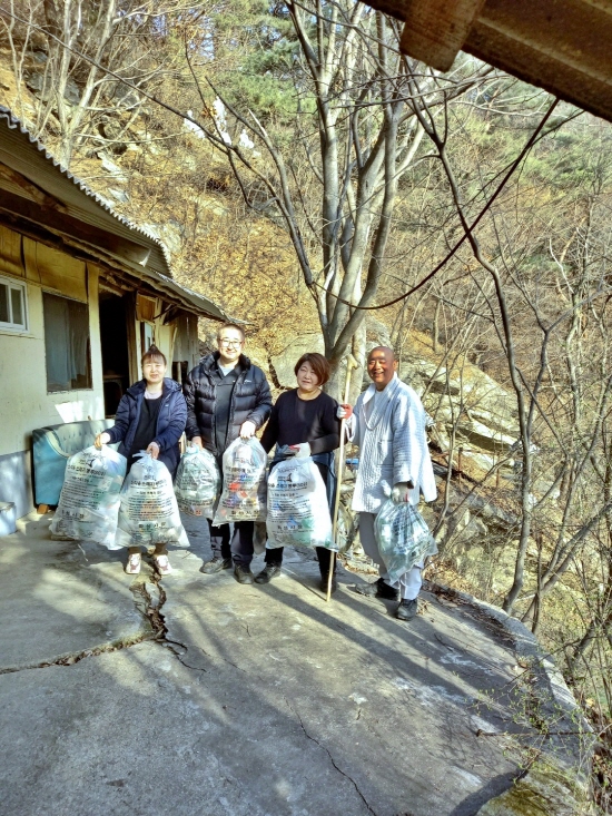운천시님이 절을 찾아온 지인들과 주변 쓰레기를 치우고 기념촬영을 하고 있다.
