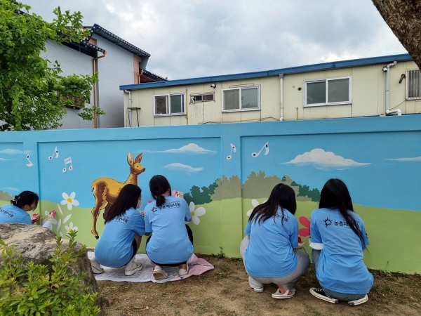 2022농촌재능나눔대학생캠프에 참여한 학생들이 첫 나눔활동으로 벽화그리기를 하고 있다