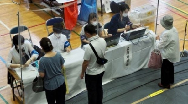 10일 일본 도쿄의 한 투표소에서 유권자들이 참의원(상원) 선거 투표 용지를 배부받고 있다. AFP=연합뉴스