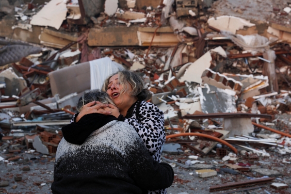 강진 발생 다음날인 7일(현지시간) 지진으로 붕괴한 튀르키예 하타이의 건물 잔해 앞에서 두 사람이 서로 끌어안고 있다.  사진=연합뉴스.